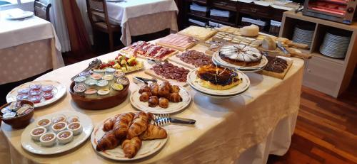 einen Tisch mit vielen verschiedenen Arten von Gebäck und Desserts in der Unterkunft Hotel Edelweiss in Camprodon