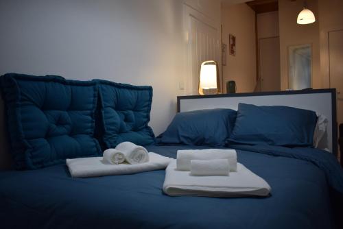 een blauw bed met handdoeken en vouwhanddoeken erop bij Studio Station 1 in Coimbra