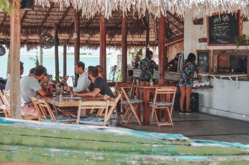 a group of people sitting at a table in a restaurant at Casa Nomade in Itarema