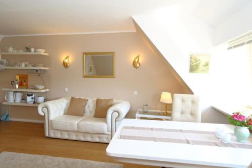 a living room with two white chairs and a couch at Teewelkenhues-Sonnenappartement in Archsum