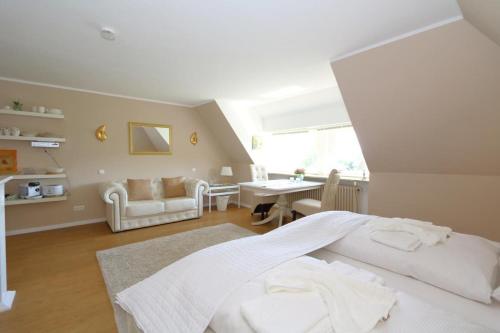 a bedroom with a bed and a living room at Teewelkenhues-Sonnenappartement in Archsum