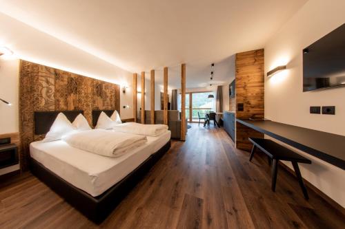 - une chambre avec un lit et un bureau dans l'établissement CHALET NORA, à San Vigilio Di Marebbe
