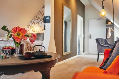 a living room with a table with flowers on it at Boutiquehotel Liebesglück - adults only in Winterberg