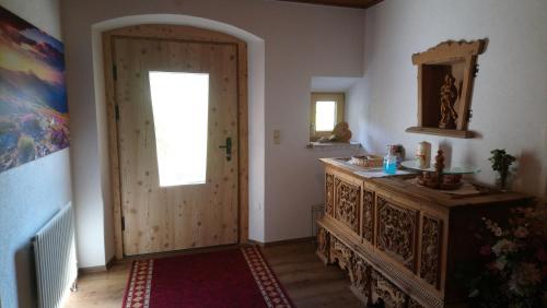 un couloir avec une porte, une fenêtre et un miroir dans l'établissement Landhaus Eberler, à Mayrhofen