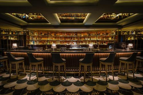 a bar with chairs in a room with books at Conrad Singapore Orchard in Singapore