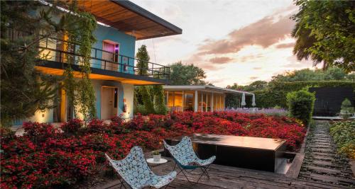 ein Haus mit einem Garten mit roten Blumen in der Unterkunft Hotel Bo in San Cristóbal de las Casas