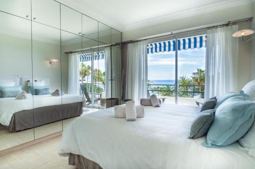 une chambre avec un grand lit et un grand miroir dans l'établissement Cannes Croisette Superbe 3P front de mer, à Cannes