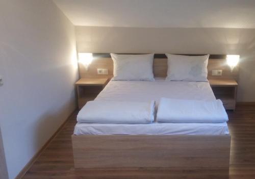 1 dormitorio con 1 cama con sábanas y almohadas blancas en Дом Бакалски-Кмета, en Narechenski Bani