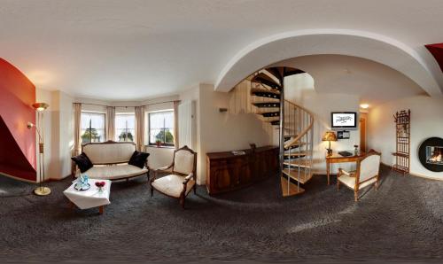 a living room with a couch and a spiral staircase at Boutiquehotel Liebesglück - adults only in Winterberg
