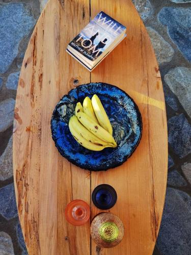 a plate of bananas on a wooden table at Damari Luxury Retreat Villas Skiathos in Skiathos Town