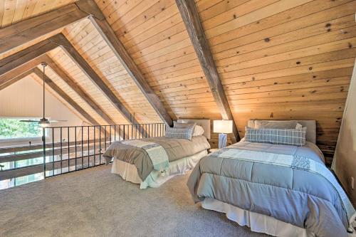 two beds in a room with a wooden ceiling at Airy Alpine Getaway with Lake Arrowhead Views! in Lake Arrowhead