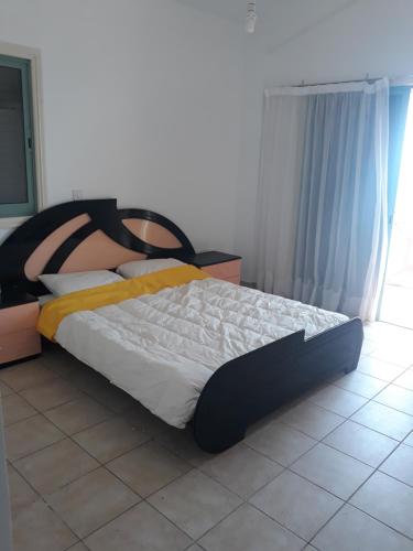 Bett in einem Zimmer mit Fliesenboden in der Unterkunft SEAFRONT BEACH PARTY VILLA in Perivolia