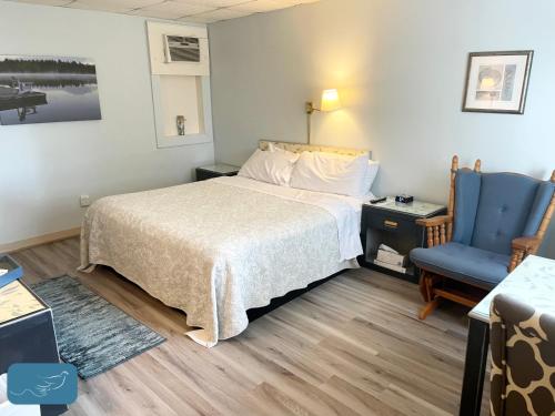 una camera d'albergo con letto e sedia blu di Skaneateles Inn on 20 ad Auburn