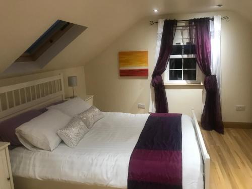 a bedroom with a large bed and a window at Tranquil Modern Countryside Bungalow in Dungannon