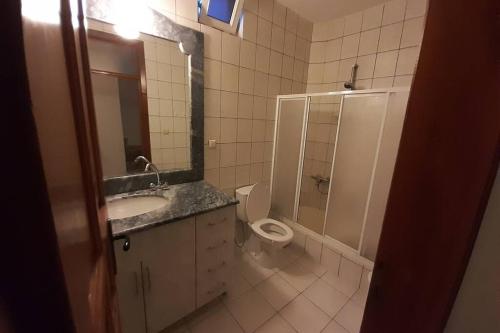 ein Badezimmer mit einem Waschbecken, einem WC und einem Spiegel in der Unterkunft Villa with pool near the sea in Konaklı