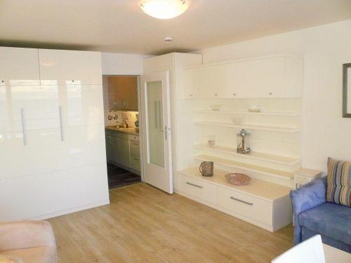 韋斯特蘭的住宿－Haus-am-Meer-App-52，客厅配有白色橱柜和蓝色沙发