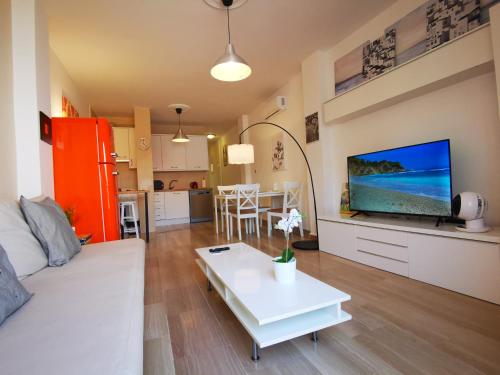 uma sala de estar com um sofá, uma televisão e uma mesa em Fuengirola Centro Histórico. A 200 m de la playa em Fuengirola