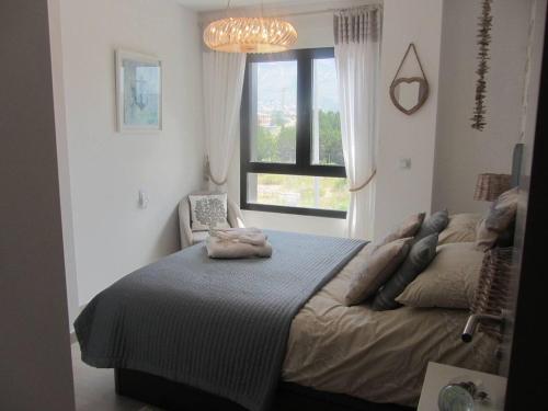 a bedroom with a large bed and a window at City Apt - Sleeps 4 Community Pool & Parking in Denia
