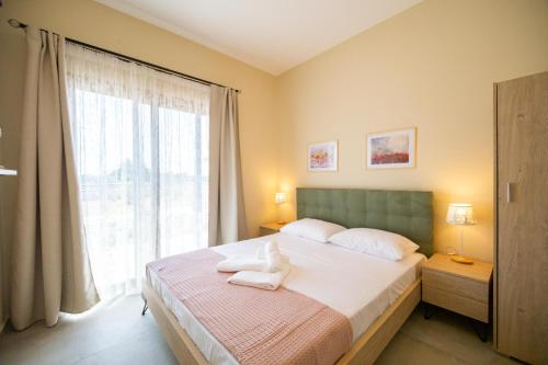 a bedroom with a bed with white towels on it at Varkes Suites 1 in Nea Potidaea