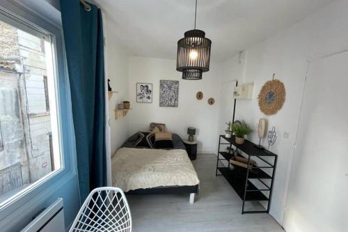 a bedroom with a bed and a window at Le Sano - Centre Historique, 2mn à pied Halles de Niort, donjon, moulin du Roc, et port Boinot - Wifi, Netflix ,2mn Hyper centre in Niort