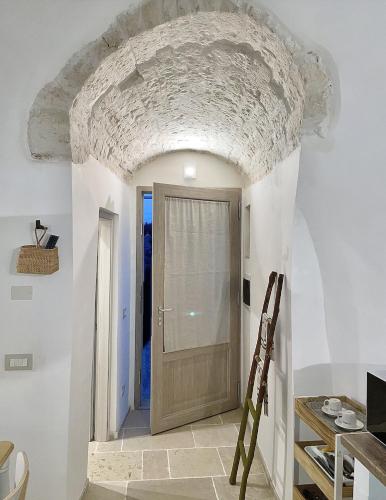 a hallway with a door in a room with white walls at Antico Trullo Pasubio in Alberobello