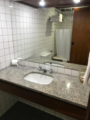 La salle de bains est pourvue d'un lavabo et d'un miroir. dans l'établissement Sol Victoria Marina Flat, à Salvador
