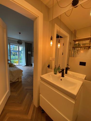 a bathroom with a white sink and a mirror at Uroczy apartament Art Marina z widokiem na rzekę i bezpłatnym parkingiem in Wrocław