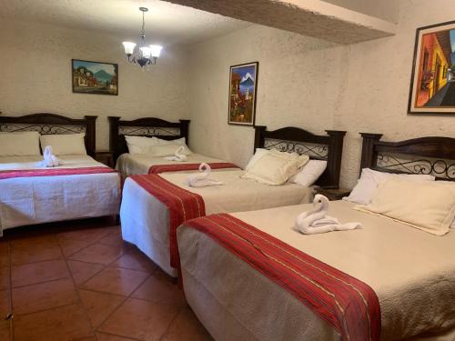 a room with two beds with swans on them at Hotel Mansion Del Rey in Antigua Guatemala