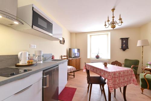 une cuisine et une salle à manger avec une table dans une pièce dans l'établissement Chez Sylvie et Joséphine, à Châtenois