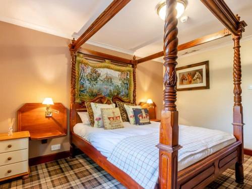 a bedroom with a four poster bed and a dresser at Dalgarven spa venue in Kilwinning