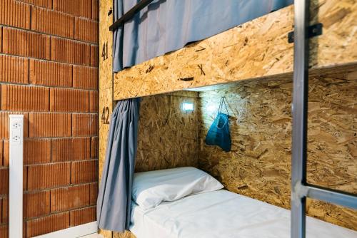 a bunk bed in a brick walled room at Albergue Santiago 15 Monforte in Monforte de Lemos