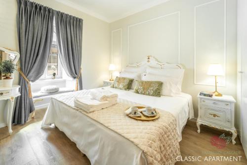 a white bedroom with a large bed with towels on it at 7 Styles Apartments by Raspberry Cascade in Faro
