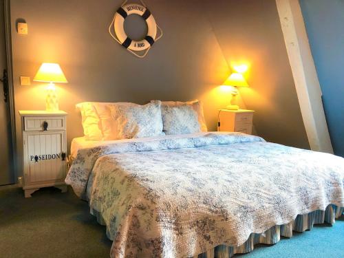 a bedroom with a large bed with two lamps at Le Vieux Pressoir in Pont-lʼÉvêque