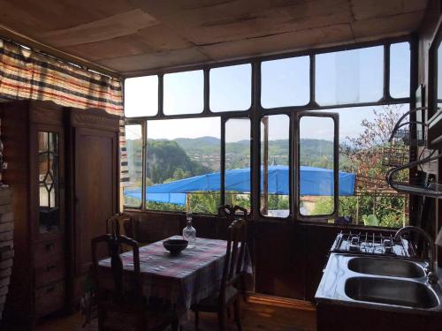 a kitchen with a table and a large window at Peaceful view in Kutaisi