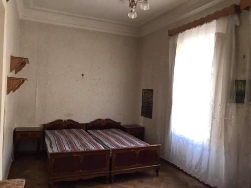 a bedroom with a bed and a large window at Peaceful view in Kutaisi
