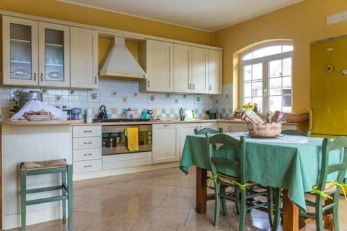 una cucina con tavolo e sedie e una cucina gialla di B&b Sant'Andrea a Morano Calabro