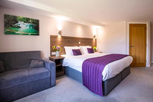 a hotel room with a bed and a couch at The Limes Country Lodge Hotel & Admiral Restaurant in Solihull