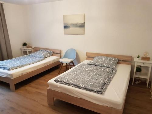 a bedroom with two beds and a chair in it at Jakobs Apartment in Sehnde