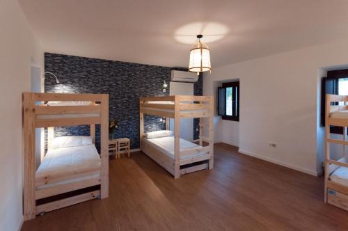 a room with three bunk beds and a brick wall at A Dársena do Francés in Redondela