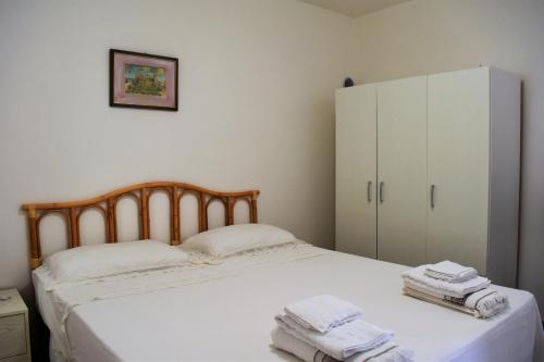 カストロ・ディ・レッチェにあるCasa vacanze Pesce azzurroのベッドルーム1室(ベッド1台、白いキャビネット付)