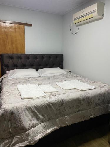 a bedroom with a large bed with a air conditioner at Casa da Árvore in Ametista do Sul