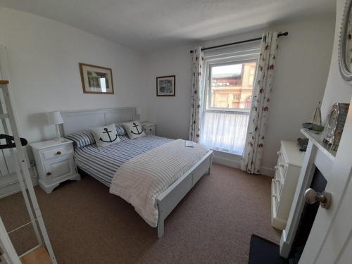 a bedroom with a bed and a window at 'Pavilion Cottage' next to Gorleston beach with sea views - pet friendly! in Gorleston-on-Sea