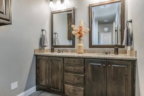 a bathroom with a sink and two mirrors at Cheerful 3 Bedroom Home, King Bed, 10 min from Palo Duro Canyon, Fireplace, Washer Dryer in Canyon