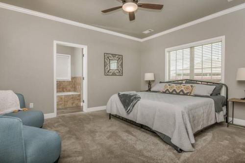 um quarto com uma cama e uma ventoinha de tecto em Cheerful 3 Bedroom Home, King Bed, 10 min from Palo Duro Canyon, Fireplace, Washer Dryer em Canyon
