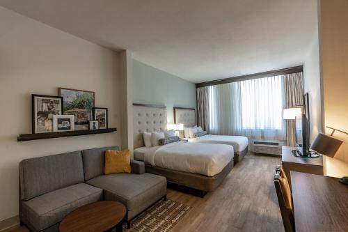 a hotel room with a bed and a couch at St Charles Coach House, an Ascend Collection Hotel in New Orleans