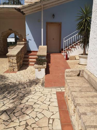 a house with a stone walkway and a door at Borgo Marino Plemmirio in Siracusa