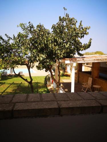 a house with a tree in front of a yard at Borgo Marino Plemmirio in Siracusa