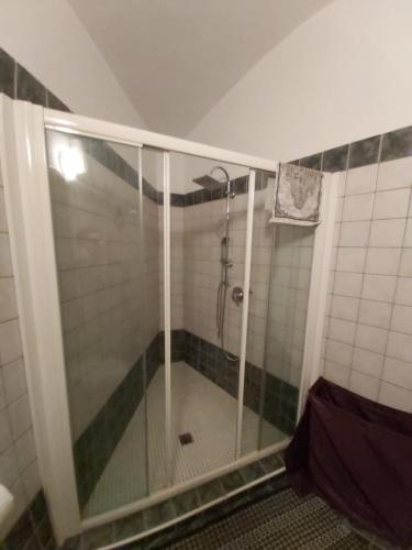 La salle de bains est pourvue d'une douche avec une porte en verre. dans l'établissement I Portici guest house, à Alexandrie
