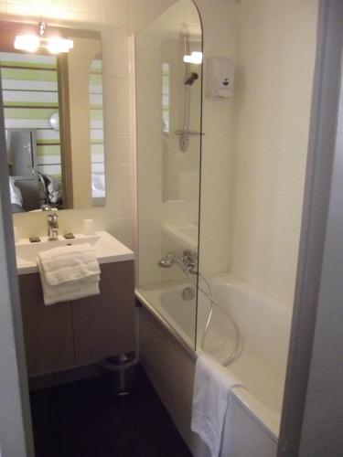 a bathroom with a shower and a tub and a sink at Le Minotel in Vitré