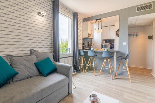 un salon avec un canapé et une cuisine dans l'établissement LYS - 7 Min des parcs Walt Disney- Parfait pour les familles- Arrivée Autonome - Parking & Wifi Gratuit, à Magny-le-Hongre